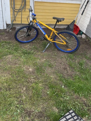Gul mountainbike med blå detaljer - Säljer en cool gul mountainbike från Power med blå fälgar och detaljer. Cykeln har svart sadel, handtag och pedaler samt växlar på styret. Perfekt för dig som vill ha en färgstark cykel för äventyr och vardag.