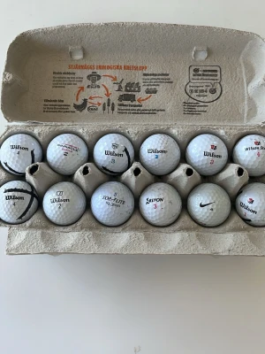 Blandade golfbollar i vit plast - Säljer ett set med 12 vita golfbollar från olika märken som Wilson, Nike, Srixon, Pinnacle och Top Flite. Bollarna är tillverkade i plast och har klassisk rund form med dimple-mönster för bättre flyg. Perfekt för dig som vill fylla på golfbagen med olika bollar.