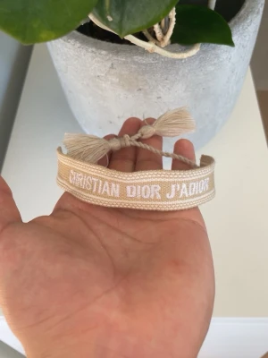 Dior armband  - Fräscht och snyggt armband i färgen beige från Dior. Perfekt för att göra sin outfit komplett!