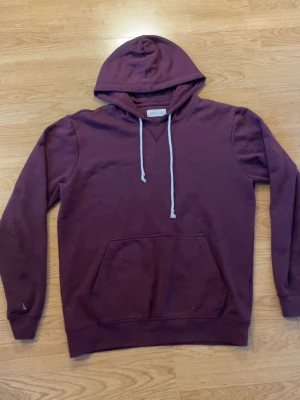 Pier one hoodie - Snygg vinröd hoodie från Pier one med klassisk känguruficka och vita dragsnören i huvan. Tillverkad i mjukt bomullsmaterial och har ribbade muddar vid ärmar och nederkant. Perfekt för en avslappnad och trendig stil. Strl L fast den passar mer M skulle jag säga. Det är den lilla färg fläcken som drar ner den i skick annars är den i väldigt bra skick ändå😁