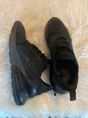 Svarta Nike Air Max 270 sneakers - Har också ett par 290s vit vin röda om nån e sugen storlek 40 400kr .Säljer ett par helsvarta Nike Air Max 270 sneakers med mesh-ovandel och stor synlig Air-enhet i hälen. Skorna har snörning, diskret Swoosh-logga och dragflik bak. Perfekta för dig som gillar sportig och modern stil.