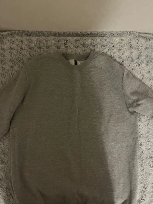  sweatshirt från Divided  - En enkel och stilren grå sweatshirt från Divided. Tröjan har rund halsringning och är tillverkad i mjukt bomullsmaterial. Perfekt för en avslappnad look och passar bra till jeans eller joggers.