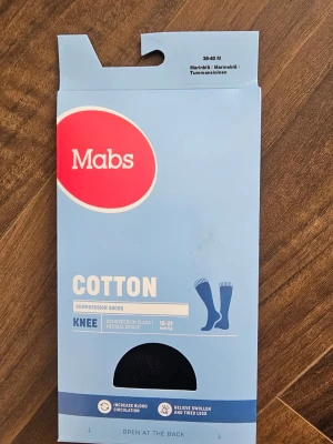 Marinblå knähöga kompressionsstrumpor Mabs - Ej använda, endast öppnat förpackning. Marinblå knähöga kompressionsstrumpor från Mabs, tillverkade i bomull och elastan. Strumporna är designade för att öka blodcirkulationen och minska svullnad i benen. Perfekt för dig som vill ha stöd och komfort under dagen.