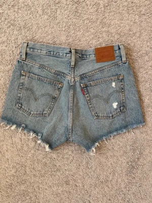 Blåa jeansshorts från Levi’s - Säljer mina blåa jeansshorts från Levi’s, de är använda fåtal gånger och i jättefint skick! Måttet över midjan är 38cm vilket motsvarar S ungefär. Dyer står även W28 på etiketten! Finns det frågor är det bara att höra av sig! Pris går att diskutera!🥰