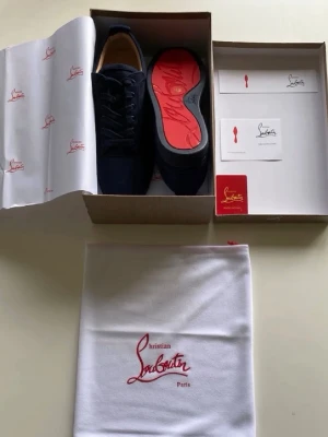 (ÄKTA)Christian Louboutin skor - Snygga mörkblå loafers från Christian Louboutin med klassisk design och ikonisk röd sula. Skorna är tillverkade i mocka och har diskreta detaljer samt medföljande dustbag och originalförpackning. Perfekt för dig som vill ha något exklusivt och trendigt. KVITTO FINNS!