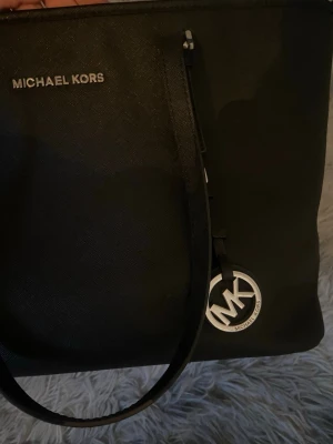 Svart toteväska från Michael Kors - Snygg svart handväska från michael kors passar både till vardags och till lyxigare tillfällen! Sparsamt använd köptes för 2600 för 2 år sen. 