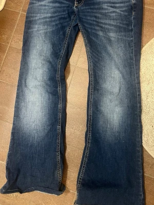 Blå bootcut jeans från 157 - Heej!!🩷 Säljer ett par blå bootcut jeans från 157 i storlek L och längd short. !!Jeansen är uppsydda hos en skräddare och passar mig som är runt 160 i längden men inte i midjan då byxorna är alldeles för stora därav är byxorna  väldigt stretchiga i midjan och stor midja!! Jeansen har en snygg tvätt med slitningar på låren och klassiska kontrastsömmar!💫