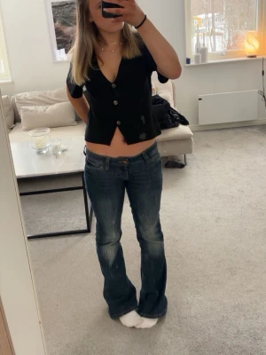 Svart croppad v-ringad topp - Snygg svart croppad topp med v-ringning och knappar framtill. Passar jätte bra till jeans!