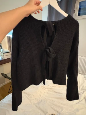 Stickad tröja Gina tricot - Svart ribbstickad tröja från Gina tricot, storlek S med två knytningar framtill!