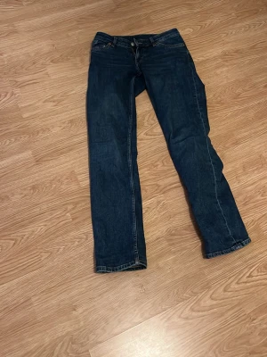 Mörkblå raka jeans - Säljer ett par mörkblå jeans med rak passform. Klassisk femficksmodell och kontrastsömmar. Perfekta till vardags för en avslappnad men snygg stil. Inget synligt märke på bilderna.