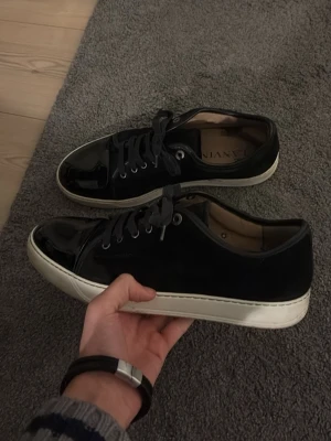 Lanvin - Svarta sneakers från Lanvin med dustbag! Givetvis äkta! Storlek är UK10 vilket motsvarar 44, kan passa 45. Skick är 8,5/10, har några små på captoen som är lite synlig om ni zoomar in. Nypris 5000kr, mitt pris 2000kr. Vid snabb affär kan jag hoppa ner någon hundralapp. Hör av er vid funderingar!
