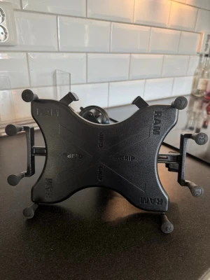 RAM X-Grip surfplattehållare svart - Säljer en svart RAM X-Grip hållare för surfplatta. Hållaren har justerbara armar och sugproppsfäste för montering på släta ytor, perfekt för bilen eller hemmet. Tillverkad i robust plast och metall för stabilitet och säkerhet. Tveka inte att höra av er alltid öppen för prisdiskussion! 