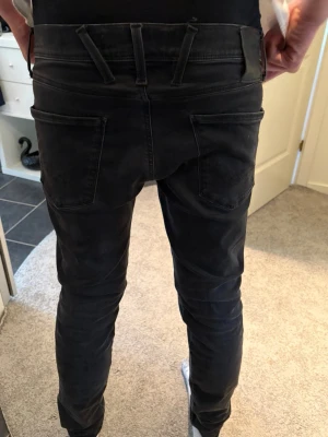 Svarta  replaye hyperflex W30/L32 - Säljer ett par svarta   jeans med klassisk femficksdesign och normalhög midja. Jeansen har en tvättad look och smala ben som sitter snyggt. Perfekta för dig som gillar en modern och stilren stil. PRISET KAN DISKUTERAS 