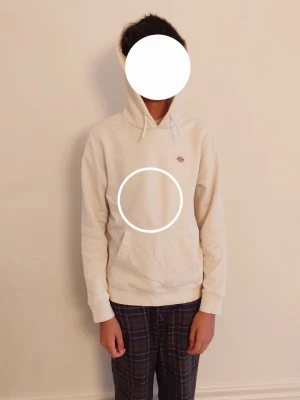 Offwhite hoodie från Dickies - Offwhite hoodie från Dickies med klassisk känguruficka och liten Dickies-logga på bröstet. Hoodien har dragsko i huvan och ribbade muddar vid ärmar och nederkant. 