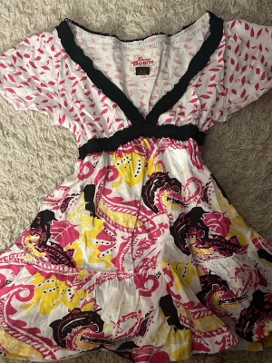 3 korta mönstrade klänningar/toppar/tröjor  Bonita - 3 korta klänningar/toppar/tröjor. Från Chica Bonita med v-ringning och resår i midjan. 25kr st. Ena klänningen har färgerna vit, rosa, gul och svart, den andra vit, blå och svart. Båda har blommigt och abstrakt mönster samt korta ärmar. Perfekta för sommarens alla tillfällen!