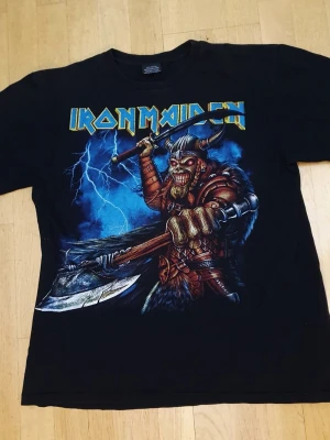 Iron Maiden T-Shirt | L / Large - T-Shirt med Iron Maiden tryck på framsidan & baksidan.  Hot Rock. Large (Mått finns på bilderna!) 100% bomull.  Se bilder.