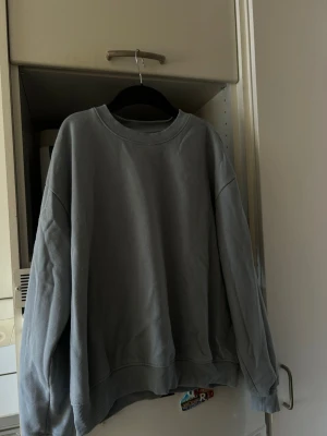 Blå sweatshirt från 157 - Mjuk och enkel blå sweatshirt från 157 med rund halsringning och ribbade muddar vid ärmslut och nederkant.
