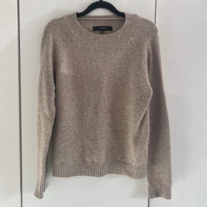 Beige stickad tröja  - Mysig beige stickad tröja från Vero Moda med rund halsringning och långa ärmar. Tröjan har ribbade muddar vid ärmslut och nederkant. Perfekt för lager på lager och enkel att matcha till olika outfits.