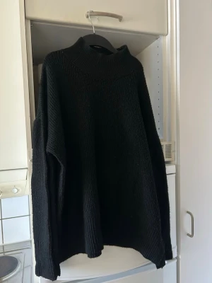 Svart oversized stickad tröja - Säljer en svart oversized stickad tröja med hög krage och långa ärmar. 