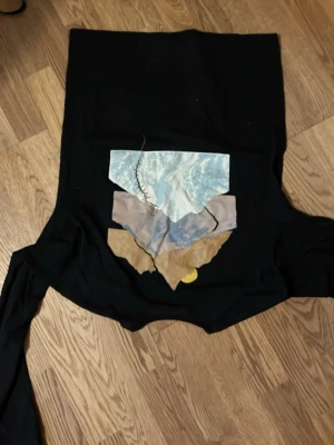 Svart Patagonia t-shirt med tryck XS - Svart t-shirt från Patagonia i regular fit med coolt bergsmotiv i blått, beige och vitt på bröstet. Tillverkad av 55% återvunnen polyester och 45% återvunnen bomull. Perfekt för dig som gillar stilren design med en twist.