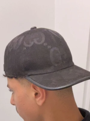 Svart keps från Gucci med GG-mönster - Snygg svart keps från Gucci  jag vill sälja den för att jag har redan 3 den är i jätte bra kvalite