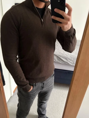 Mörkbrun stickad tröja half zip - Mörkbrun stickad half zip tröja från John Henric i storlek S. Tröjan har ribbade muddar vid ärmslut och nederkant, samt en hög krage som kan bäras öppen eller stängd. Inga defekter alls! Perfekt nu till våren! Vid funderingar är det bara att kontakta!🌟