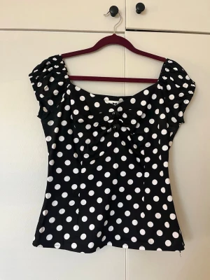 Prickig topp - Söt prickig figursydd topp med söta knappar till detalj, storlek S i mycket bra skick. Har även en dragkedja på ena sidan. 