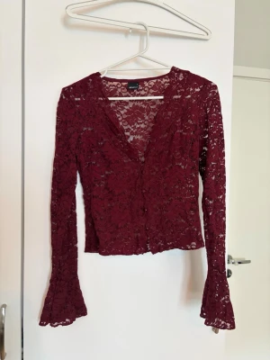 Gina tricot spetströja - Vinröd, V-ringad spetströja med utsvängda armar från Gina tricot. Finns lite tecken på slitage (små trådar som syns) men annars är tröjan i fint skick. 🌼