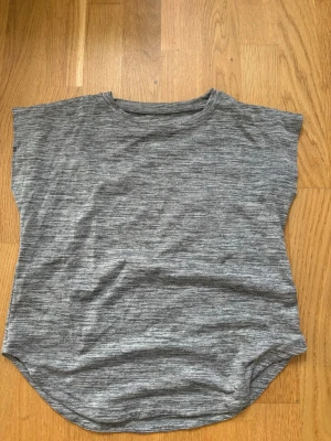 Gråmelerad träningströja från Oxide - Snygg gråmelerad t-shirt från Oxide med rund hals och avslappnad passform. Tillverkad i mjukt material som känns skönt mot huden. Perfekt till jeans eller shorts för en enkel och clean look.