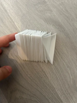 Vikbar vit plastbehållare - Säljer en vikbar behållare i vit plast med triangulära fack. Perfekt för småförvaring eller som organiserare för småsaker. Behållaren kan dras ut och vikas ihop för smidig förvaring. Enkel och stilren design.