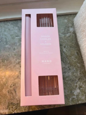 Ljusstakar och ljus från Mano Atelier - Säljer ett set med två rosa dinner candles och tillhörande ljushållare från Mano Atelier. Ljusen är långa och smala, och hållarna är genomskinliga med stilren design. Perfekt för att skapa mysig stämning hemma. Ny skick, köpta för 300 säljer för 80