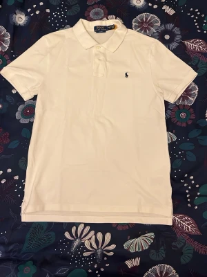 Ralph Lauren pikétröja - Klassisk vit pikétröja från Ralph Lauren i största pojkstorleken (se bild), passar Xs/S. Nypris ca 1300. Skriv gärna vid funderingar !!