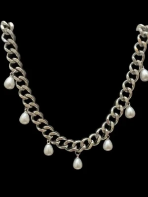 Silver halsband med pärlor - Ett chunky silverfärgat halsband med bred kedja och hängande vita pärlor. Halsbandet har en modern design med flera pärlor som ger en cool och elegant look. Perfekt för att lyfta din outfit med en trendig touch.