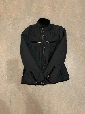 Quiltad jacka från Stockh LM - En snygg mörkblå quiltad jacka med gulddetaljer från Stockh LM i toppskick i storlek 38. För mer bilder och frågor om passform, frakt m.m. Tveka inte att höra av dig! 💙