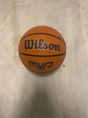 Wilson MVP basketboll orange - Wilson MVP basketboll i klassisk orange färg med svarta detaljer. Tillverkad i slitstarkt syntetmaterial och har tydlig textur för bra grepp. Perfekt för både inomhus- och utomhusspel. Stor och rund form, med tydlig Wilson-logga.