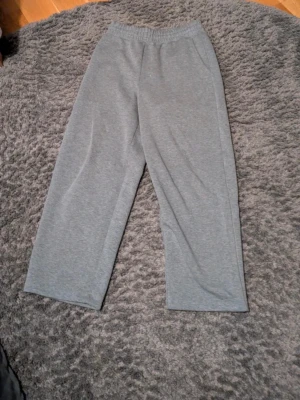 Gråa mjukisbyxor med resårmidja från uniglo  - Säljer ett par klassiska gråa mjukisbyxor med rak passform och resår i midjan. Byxorna är tillverkade i mjukt och stretchigt material, perfekta för chill dagar hemma eller när du vill vara bekväm. Inga synliga loggor eller detaljer. Från uniglo, andvända typ 5 gånger ny skick 