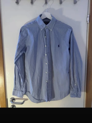 Randig skjorta Ralph Lauren  - En vit och blå randig skjorta från Ralph Lauren, jätte fint skick och de är storlek S och slim fit, perfekt skjorta för sommarn