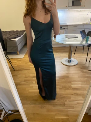 Mörkgrön balklänning  - Supersnygg mörkgrön balklänning med slits från Bubbleroom💕💕 Det är storlek 36 men passar även mig som har storlek xs. Den är uppsydd några cm längst ner och passar perfekt på mig i längden med klackar (jag är 166cm lång). Använd vid ett tillfälle några år sedan och har några tråddragningar som jag inte tycker syns☺️