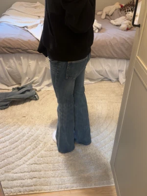 weekday blå bootcut jeans - Säljer ett par blå bootcut jeans med utsvängda ben och klassisk femficksmodell. Jeansen har en snygg tvättad look och normal midja. Perfekta för dig som gillar en avslappnad men trendig stil.