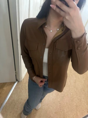 Helt ny Carin Wester skjortjacka i konstläder – Storlek M - Säljer en superfin och helt oanvänd skjortjacka från Carin Wester. Prislappen sitter fortfarande kvar! Original pris: 500kr (kolla alla bilder)  Märke: Carina Wester Skick: Helt ny/Oanvänd Storlek: 38 = M Pris: 399kr