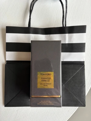 Tom Ford Tobacco Vanille EdP 100 ml KVITTO FINNS - Tom Ford Tobacco Vanille Eau de Parfum 100 ml i elegant mörkbrun rektangulär förpackning med guldfärgade detaljer. Lyxig doft med inslag av tobak och vanilj, perfekt för dig som gillar exklusiva och varma parfymer. Kommer i originalförpackning.