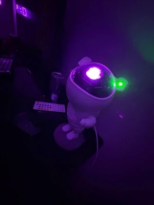 Astronaut lampa med LED-projektion - Cool astronautformad lampa med LED-projektion som lyser i olika färger. Lampan är vit och har en hjälm i genomskinlig plast där ljuset projiceras ut. Styrs med fjärrkontroll och ansluts via kabel. Perfekt som dekoration i rummet.