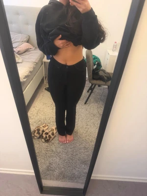 Svarta flared jeans med hög midja - Säljer ett par svarta skinny jeans med hög midja och klassisk femficksdesign. Jeansen har en tight passform hela vägen ner och är perfekta för dig som gillar en stilren och enkel look. Materialet är stretchigt för extra komfort.