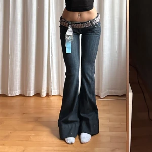 Lågmidjade bootcut jeans - Low waist, bältet kommer ej med, själva kvittot är på bältet och inte byxorna, har installerat den röda trådet för att göra byxorna tighta och anpassbara till den som köper. Dragskedjan brukar gå ner ibland men det går att fixa själv, annars true vintage, 2000s jeans, du hittar inte en bättre