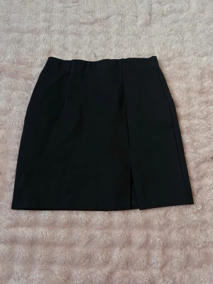 Svart kjol - Säljer denna svarta kjol med ett snitt på höger sida🫶🏻