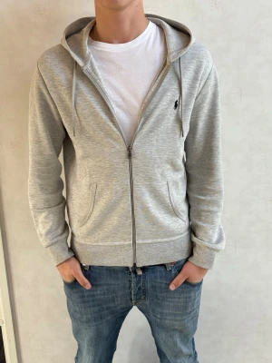 Ralph Lauren zip hoodie  - Säljer en sjukt snygg Ralph Lauren hoodie! Skicket är som nytt men det är en liten liten fläck som syns på sista bilden (går säkert bort i tvätten) Bara höra av sig vid frågor eller funderingar! Modellen på bilden är 184cm och väger 80kg