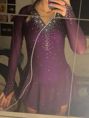 Lila konståknings klänning💜 - Säljer en lila konståknings klänning i storlek S. Passar mig som är 164cm lång och har storlek S/XS. Den är i jättebra skick här bara använt den ungefär 5 gånger. Säljer den eftersom jag har slutat på konståkning. Den är ifrån light in the box, har bra kvalite. Köpte den för 1100kr så säljer den för 750kr. Alla kristaller sitter kvar på klänningen och har en liten extra påse med kristaller om nån kristallerna åker av.