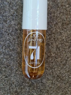 Sol de Janeiro Cheirosa 71 Parfymmist - Sol de Janeiro Cheirosa 71 är en parfymmist i en genomskinlig, bärnstensfärgad plastflaska med vit kork. Flaskan rymmer 240 ml och har en modern, rundad form. Doften är känd för sina varma, söta toner och är perfekt för dig som gillar tropiska vibbar. Helt ny och oanvänd med plasten kvar