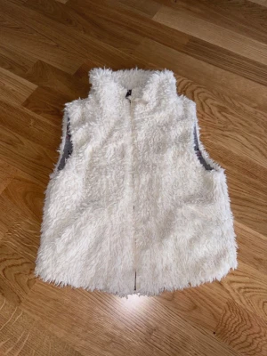 Fluffig väst 140 - Fluffig väst från H&M i storlek 140.  Har två fickor fram.  Nytvättad. Mycket fint skick.