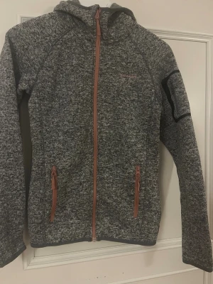 Gråmelerad hoodie från Bergans - Gråmelerad hoodie från Berganskvalitet, perfekt för lager-på-lager. Snygga detaljer och huva för extra komfort.och är oanvänd 